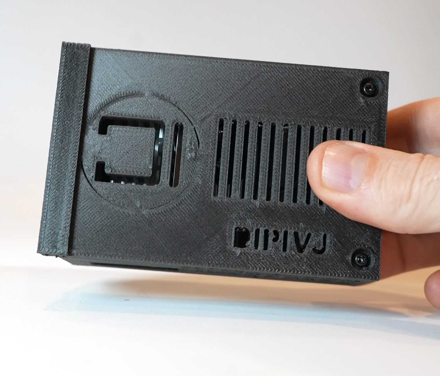 Black 3D-printed object held by a hand with 'DIPIVJ' branding.